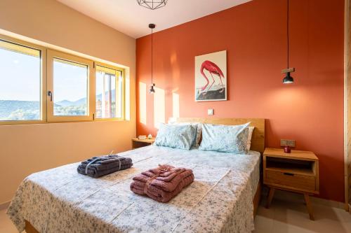 a bedroom with a bed with two bags on it at Martinia Pool Getaways - Majestic Panoramic Views in Áno Ámfia
