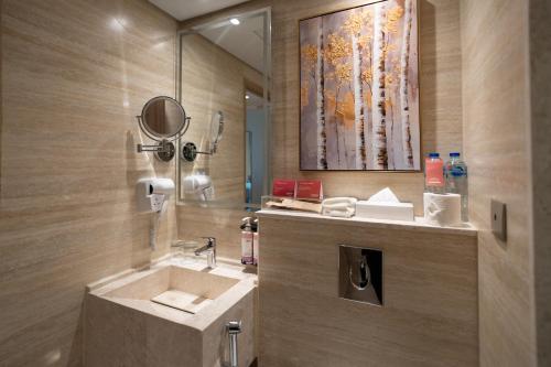 une salle de bain avec un lavabo et un miroir dans l'établissement Movenpick Makkah Hajar Tower, à La Mecque