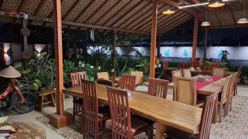 a restaurant with a wooden table and chairs at Alamanda Family Villas, Pool & Local Tours in Yogyakarta