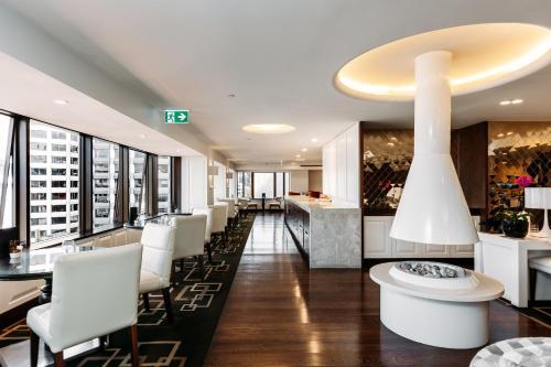 a restaurant with white chairs and a bar with windows at InterContinental Wellington by IHG in Wellington