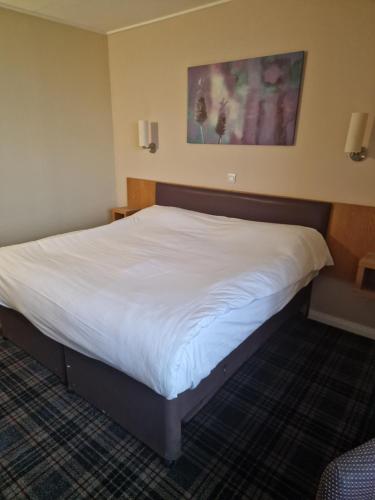 a large bed in a hotel room at Britannia Inn Glasgow in Glasgow