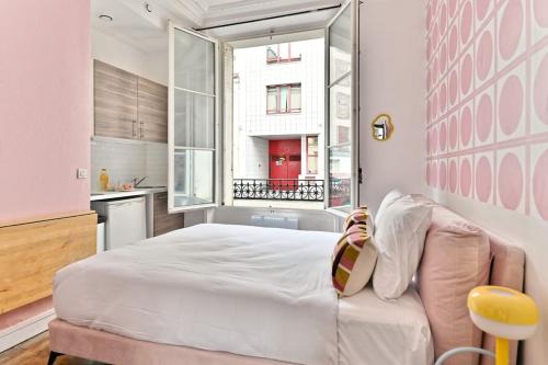 une chambre avec un lit blanc et une fenêtre dans l'établissement Studio central proche Vaugirard - II, à Paris