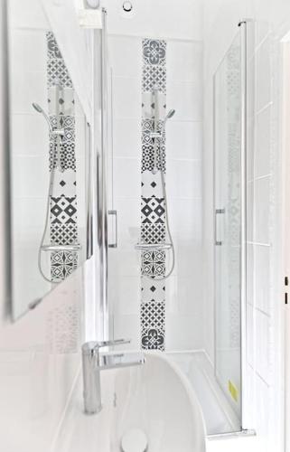 une salle de bain blanche avec un lavabo et un miroir dans l'établissement Studio central proche Vaugirard - II, à Paris