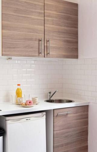 une cuisine avec des armoires en bois et un évier dans l'établissement Studio central proche Vaugirard - II, à Paris