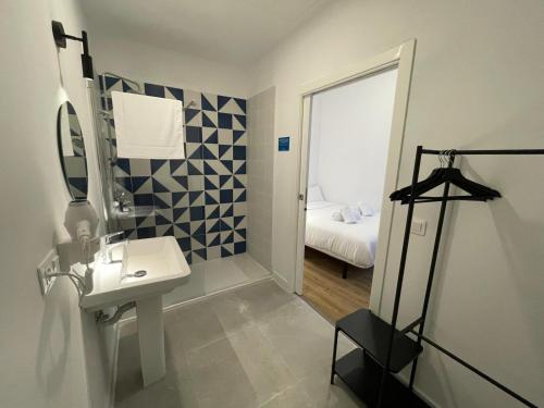 Un baño con lavabo, espejo y cama. en Hotelito Boutique Tenerife Guimerá, en Santa Cruz de Tenerife