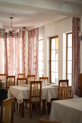 a dining room with tables and chairs and windows at Del Monte Predeal in Predeal