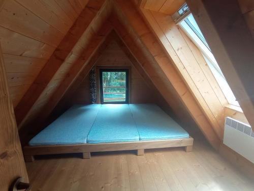 a mattress bed in a attic with a window at Chata Eva in Planá nad Lužnicí