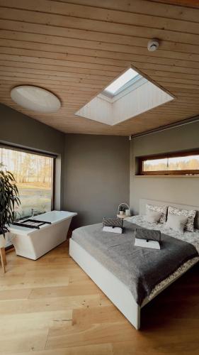 a bedroom with two beds and a bath tub at Dabas Osta in Jūdaži