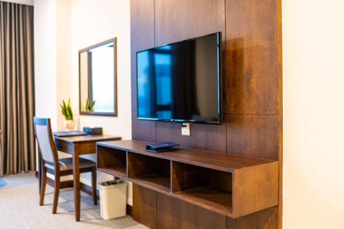 a room with a desk and a television on a wall at Peace Hotel Hạ Long in Ha Long