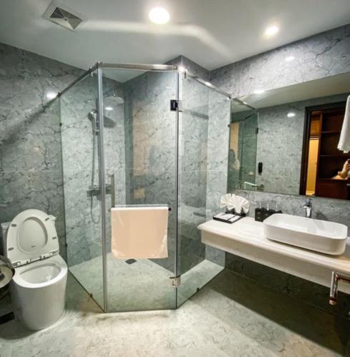 a bathroom with a shower and a toilet and a sink at Peace Hotel Hạ Long in Ha Long