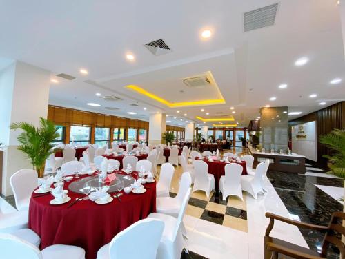 a banquet hall with red and white tables and white chairs at Peace Hotel Hạ Long in Ha Long