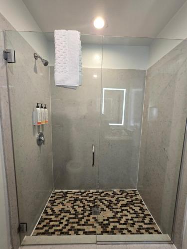 a bathroom with a shower with a glass door at Marina Village Inn in Alameda