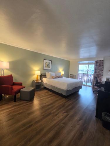 a bedroom with a large bed and a living room at Marina Village Inn in Alameda