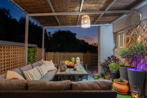 een patio met een bank en een tafel in de tuin bij San Francisco maisonette in Rhodos-stad