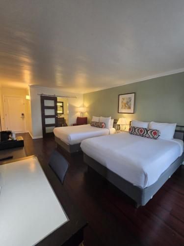 a hotel room with two beds and a chair at Marina Village Inn in Alameda