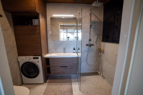 une salle de bain avec douche et machine à laver dans l'établissement Marina Resort C9, à Kalajoki
