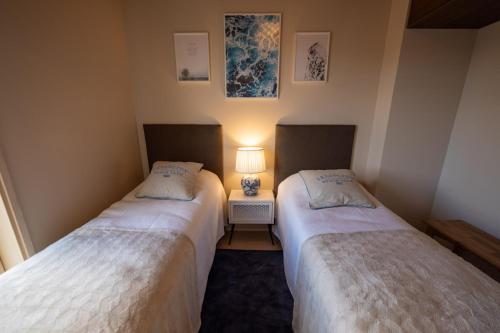 deux lits dans une chambre avec une lampe sur une table dans l'établissement Marina Resort C9, à Kalajoki