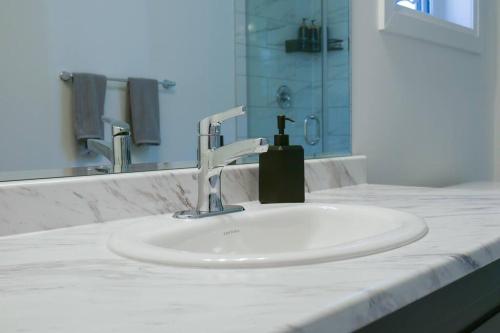 a bathroom sink with a soap dispenser on it at Spacious 3 Bdrm Retreat, Muskoka Room & Fireplace in Bracebridge