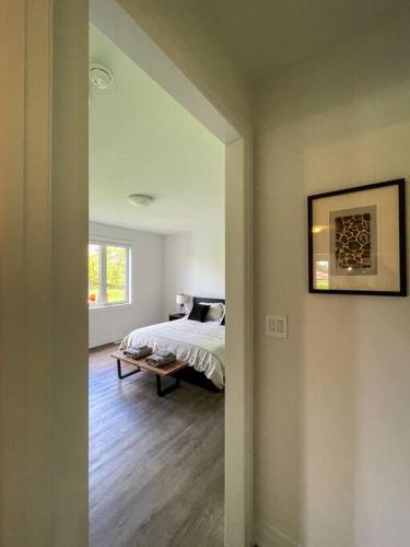 a bedroom with a bed and a table in it at Spacious 3 Bdrm Retreat, Muskoka Room & Fireplace in Bracebridge