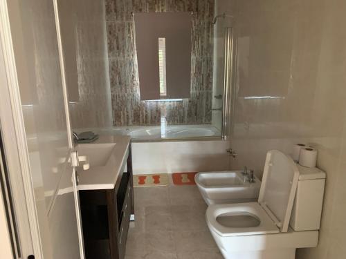 ein Badezimmer mit Toilette, Waschbecken und Badewanne in der Unterkunft Casa en Yanda, sobre Ruta Nacional 9, salida directa Autódromo in Zanjón