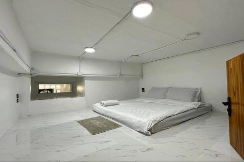a white bedroom with a large bed in it at Megun capsule 150 cm in Bang O