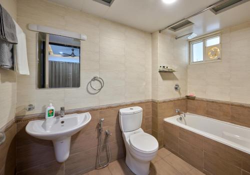 a bathroom with a toilet and a sink and a tub at BayView Retreat Premium Stay at Marine Drive Kochi in Cochin