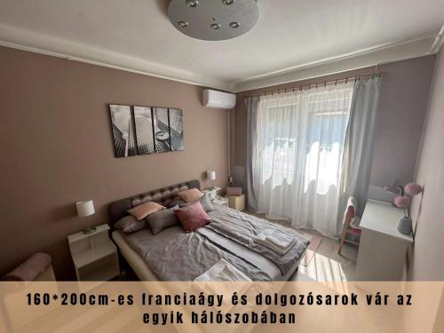 a bedroom with a bed and a large window at Estina House in Balatonboglár