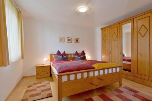 瑟尔Bichler Katrin, Ferienwohnung的一间卧室配有一张带紫色枕头的大木床