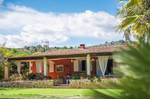 a small red house with a palm tree at Ideal Property Mallorca - Can Caragol Font de Sa Cala in Capdepera