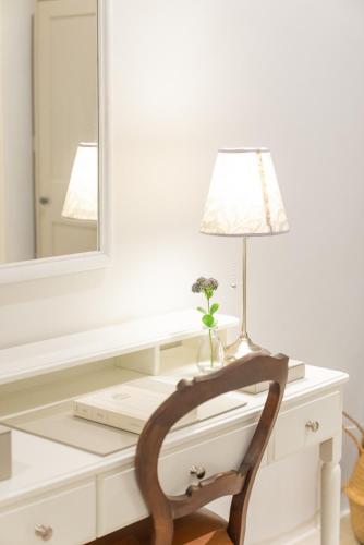 a desk with a lamp and a vase with flowers on it at Green Me Organic Farm Khao Yai กรีนมี ออแกนิคฟาร์ม เขาใหญ่ in Ban Khlong Yang