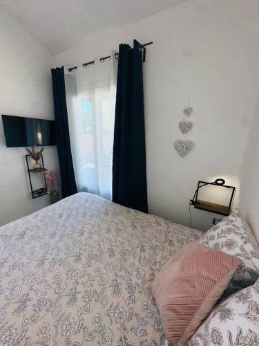 a bedroom with a bed and a window at Les Appartement du Mas - RUBIS in Aigues-Mortes