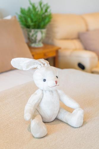 a white stuffed rabbit sitting on a bed at Green Me Organic Farm Khao Yai กรีนมี ออแกนิคฟาร์ม เขาใหญ่ in Ban Khlong Yang