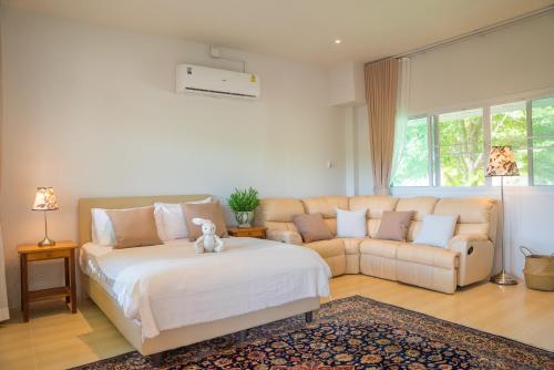 a bedroom with a large bed and a couch at Green Me Organic Farm Khao Yai กรีนมี ออแกนิคฟาร์ม เขาใหญ่ in Ban Khlong Yang