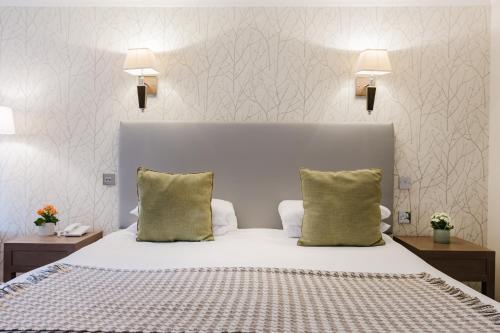 a bedroom with a large white bed with two pillows at Winchester Royal Hotel in Winchester