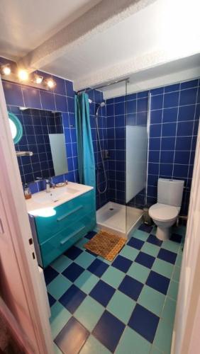 La salle de bains est pourvue de carrelage bleu, de toilettes et d'un lavabo. dans l'établissement Maison sur la roche, vue mer exceptionnelle, quartier des peintres, calme, clim et wifi, parking privé, plages à pied, à Collioure