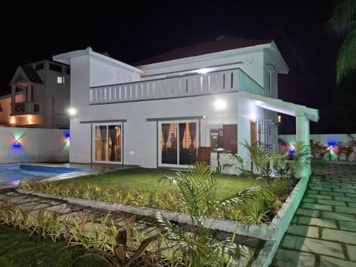 a large white house at night with at Vasantham Villas ECR 3BHK in Tirupporūr