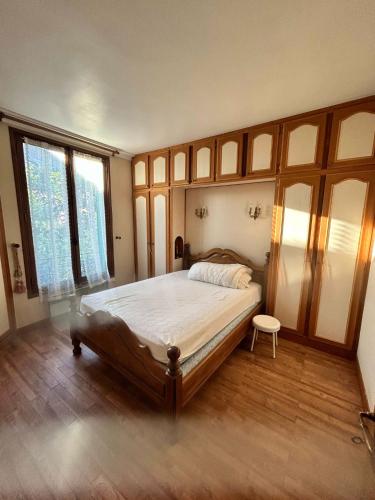 - une chambre avec un grand lit, du parquet et des fenêtres dans l'établissement Belle F3 L'Hays les roses, à LʼHay-les-Roses