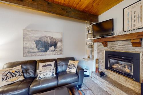 a living room with a leather couch and a fireplace at Breckenridge Bliss Retreat in Breckenridge