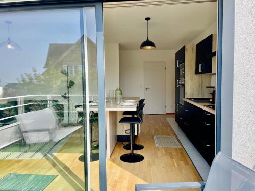une cuisine avec une table et une vue sur un balcon dans l'établissement Joli appartement avec balcon au pieds des commences et des plages, à Carantec