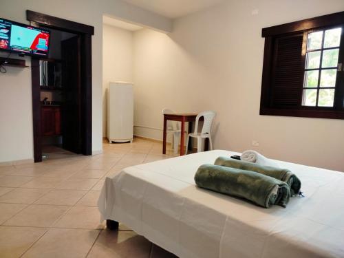 a bedroom with a bed with a green pillow on it at Mansão Sunset Beach House in São Sebastião