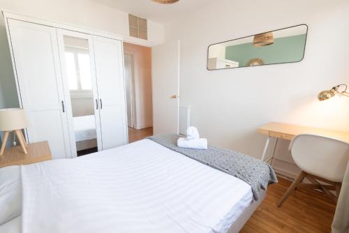 une chambre blanche avec un lit et un bureau dans l'établissement Appartement 3 chambres rénové Lorient Centre par Groom, à Lorient