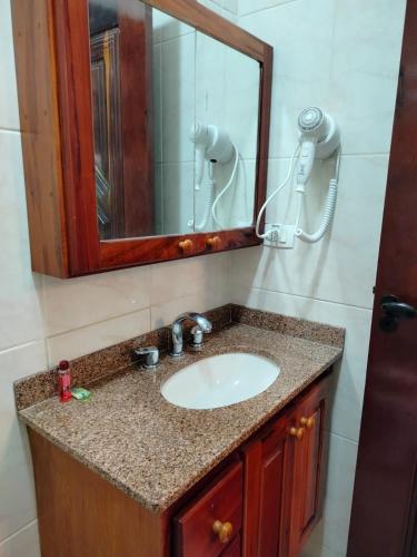 a bathroom with a sink and a mirror at Mansão Sunset Beach House in São Sebastião