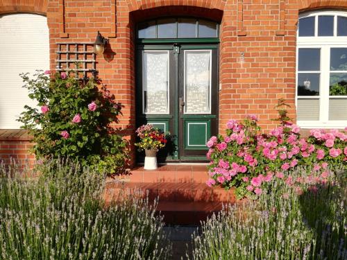 a green door on a brick house with flowers at Ferienwohnung Seeblick in Plau am See
