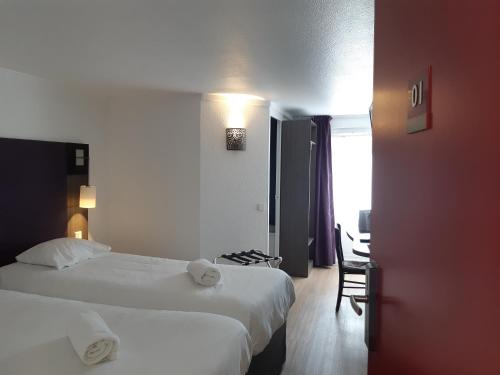 a hotel room with two beds and a table and chairs at Brit Hotel Reims La Neuvillette in Reims