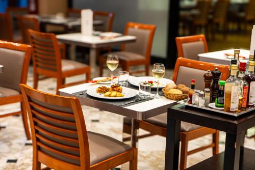 a table with a plate of food and glasses of wine at Abacus Hotel in Sesto San Giovanni