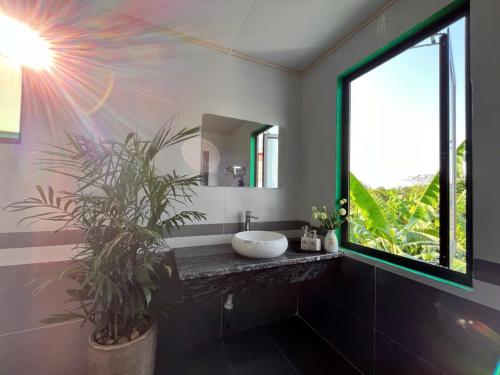 a bathroom with a sink and a large window at The Green House Homestay in Ninh Binh