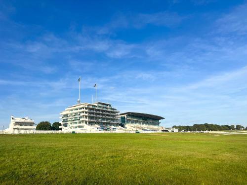 a large white building with two flags on top of it at Cozy Maisonette in Langley Vale in Kingswood Warren