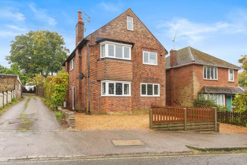 an old brick house with a fence in front of it at Cozy Maisonette in Langley Vale in Kingswood Warren
