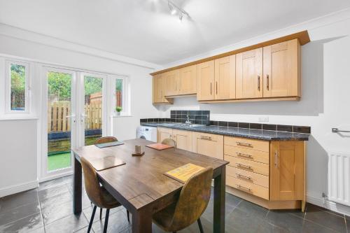 a kitchen with a wooden table and chairs at Cozy Maisonette in Langley Vale in Kingswood Warren