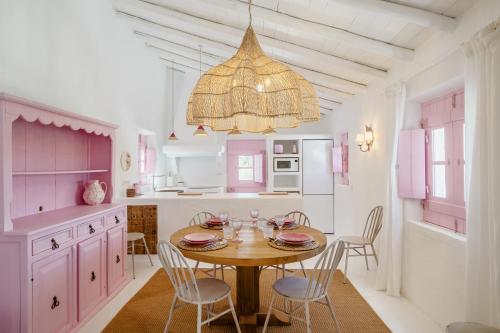 a kitchen with a table and chairs and a chandelier at Casa da Encosta in Silves